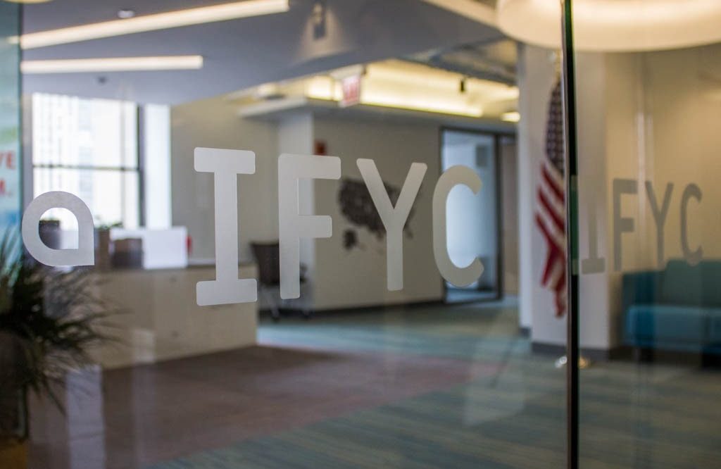 IFYC logo on glass door in office space