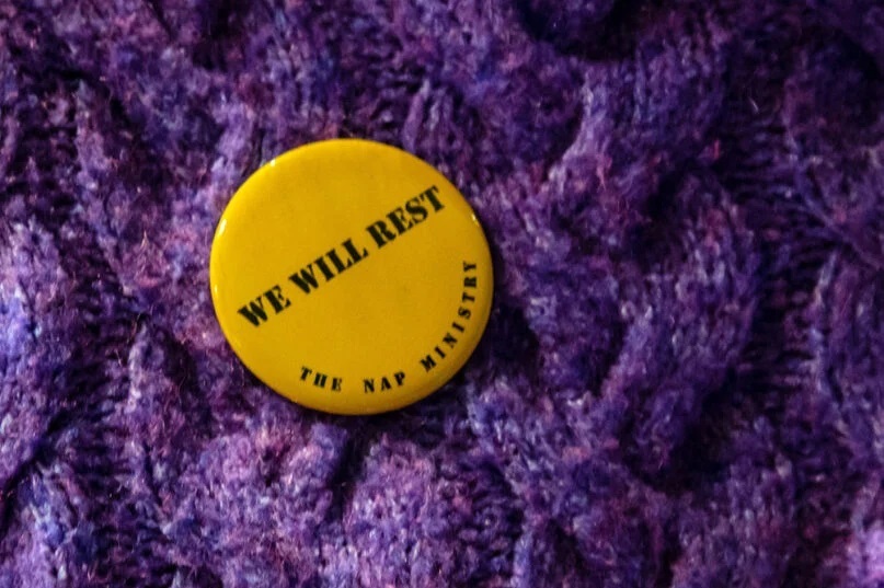 An individual wears a “We Will Rest” pin from The Nap Ministry. Photo by Stanchez Kenyata